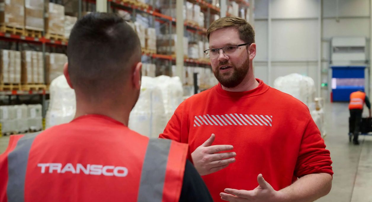 Transco Logistikmitarbeiter im Gespräch in Lagerhalle