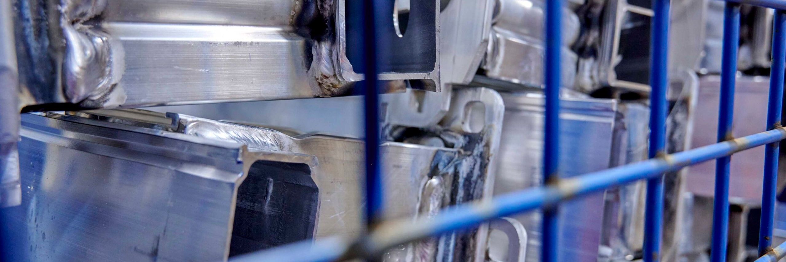 Nahaufnahme Metallteile in blauer Gitterbox