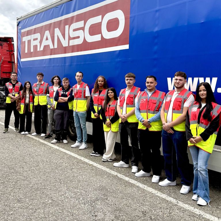 Auszubildende vor einem Transco LKW